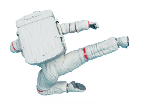 astronaut is doing an action flying side kick in rear view